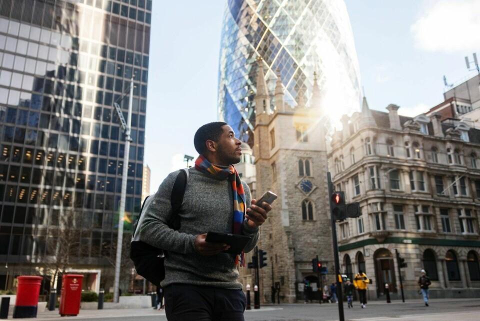 International student exploring London with phone and tablet